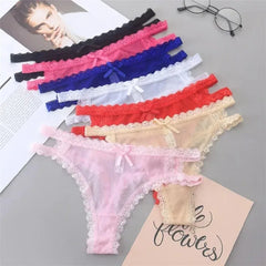 Set of colorful lace lingerie on a gray surface with a magazine and glasses in the background.
