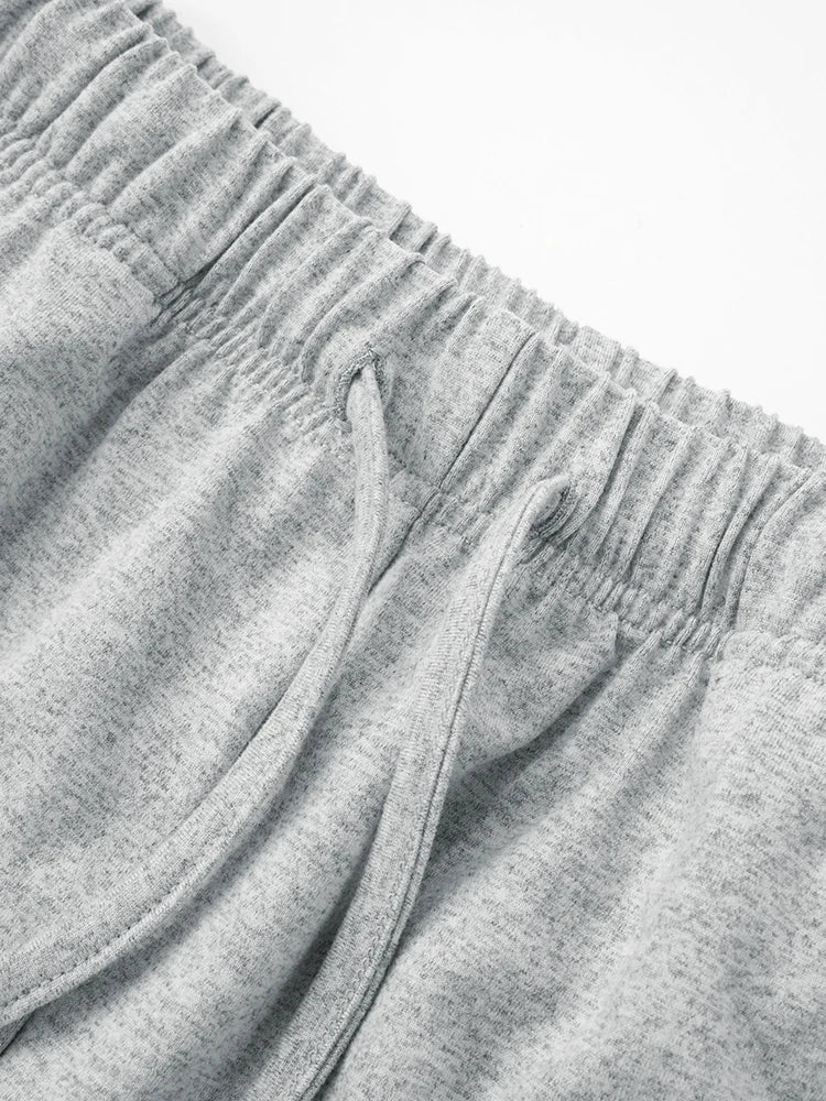 Close-up of gray sweatpants with a focus on the waistband and fabric texture.