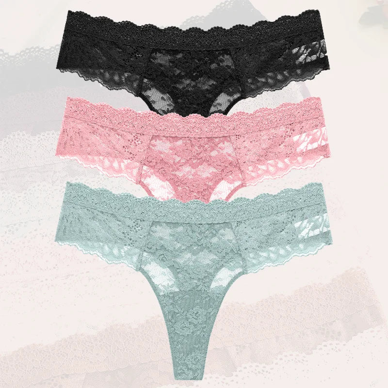 Three pairs of lace underwear in black, pink, and green on a textured background.