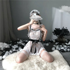Person wearing a silver dress with black accents sitting on a white surface.