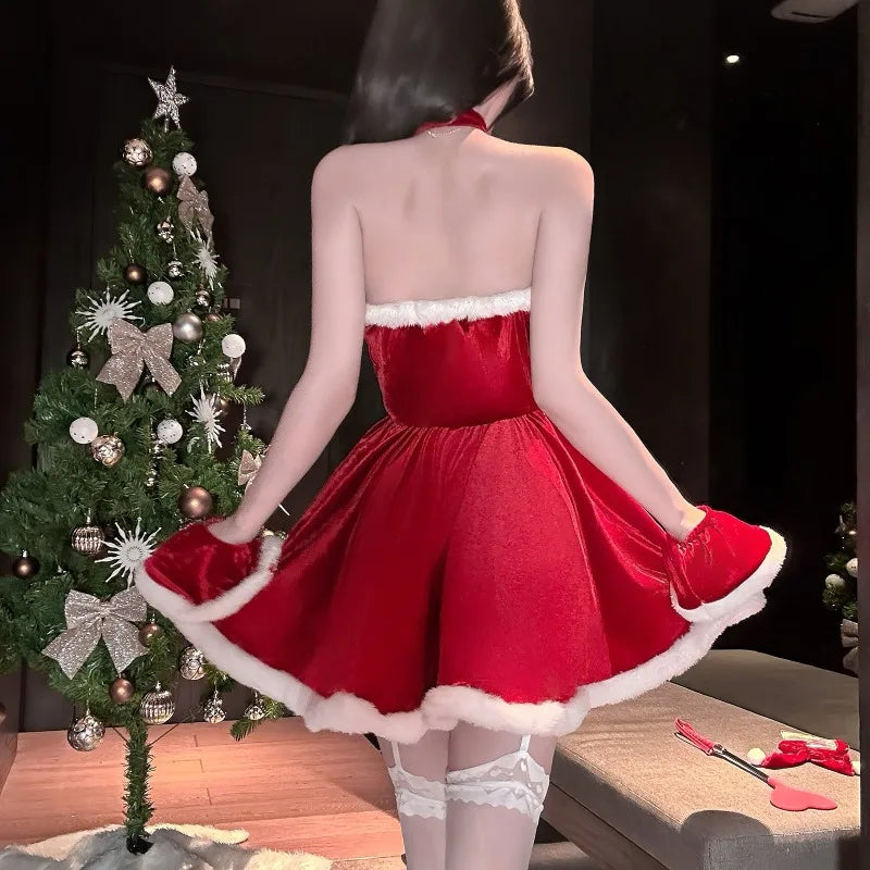 Person wearing a red dress with white trim in front of a decorated Christmas tree.