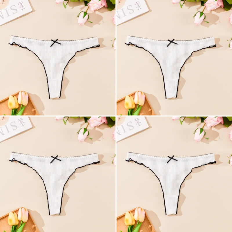 White thong with black lace trim on a beige background with flowers and text.