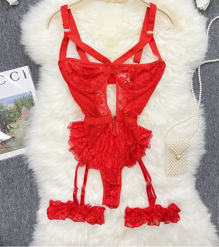 Red lace lingerie set on a hanger with a fluffy white surface and flowers in the background.