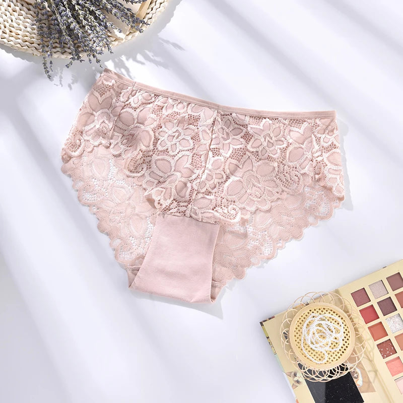 Lace pink underwear on a white surface with a makeup palette and dried lavender in the background.