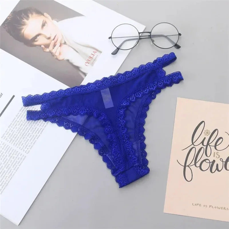 Blue lace lingerie on a gray surface with a magazine and eyeglasses.