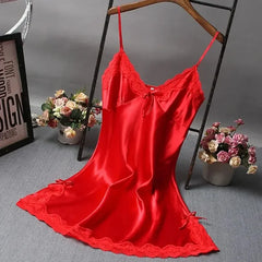 Red satin slip dress on a hanger with flowers and a frame in the background