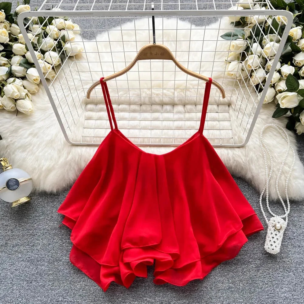 Red spaghetti strap top on a hanger with decorative background
