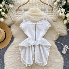 White lace romper on a hanger with decorative elements on a soft surface