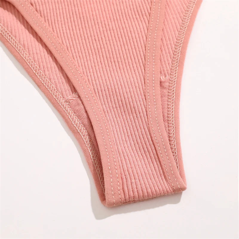 Close-up of pink ribbed fabric with visible stitching on a white background