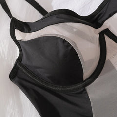Black lingerie set with mesh panels on a light background