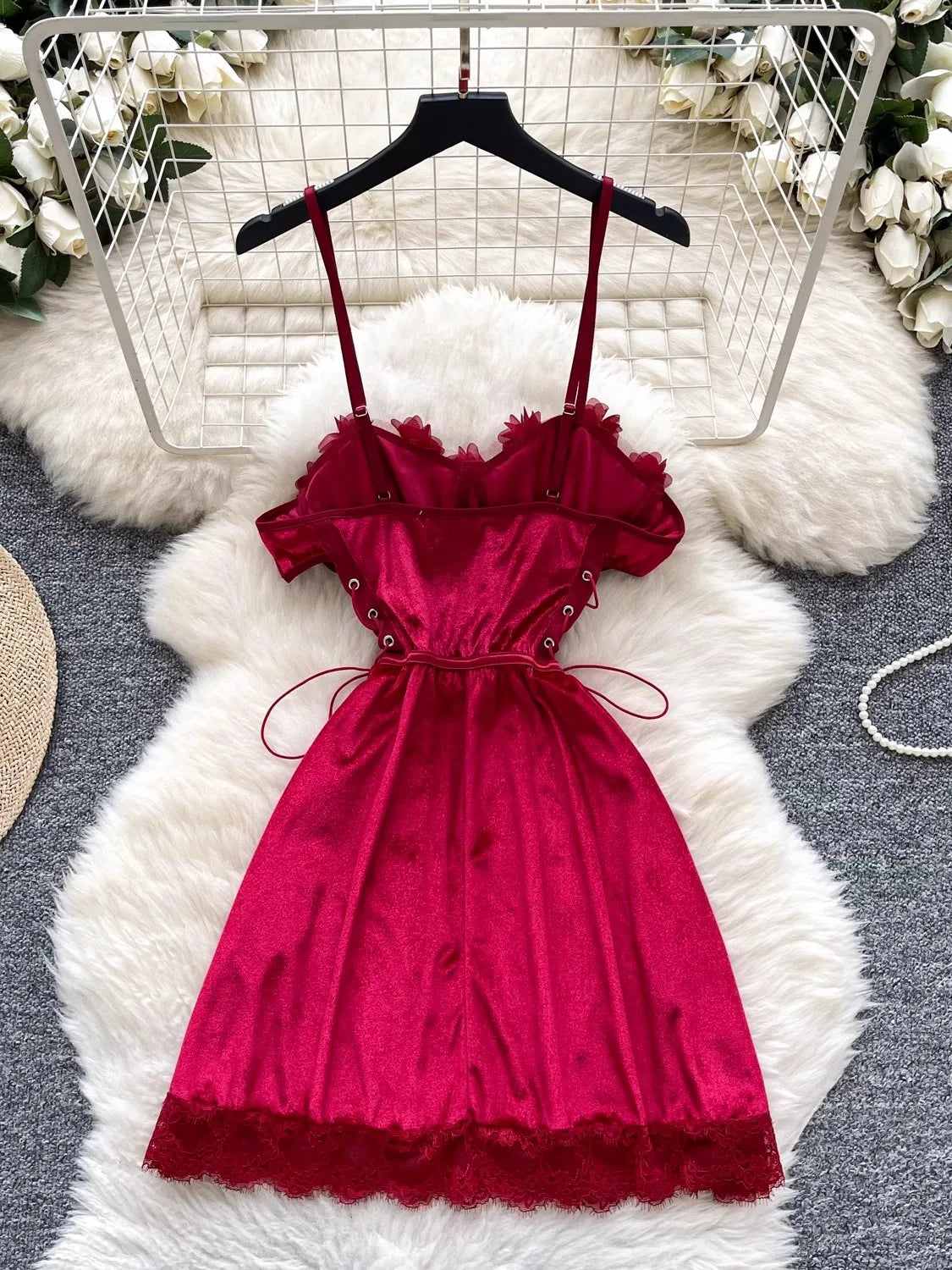 Red dress on a hanger with a white floral background