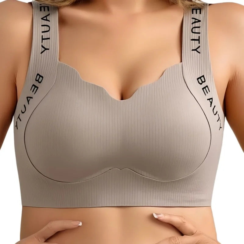 Beige sports bra with 'BEAUTY' branding on straps against a white background