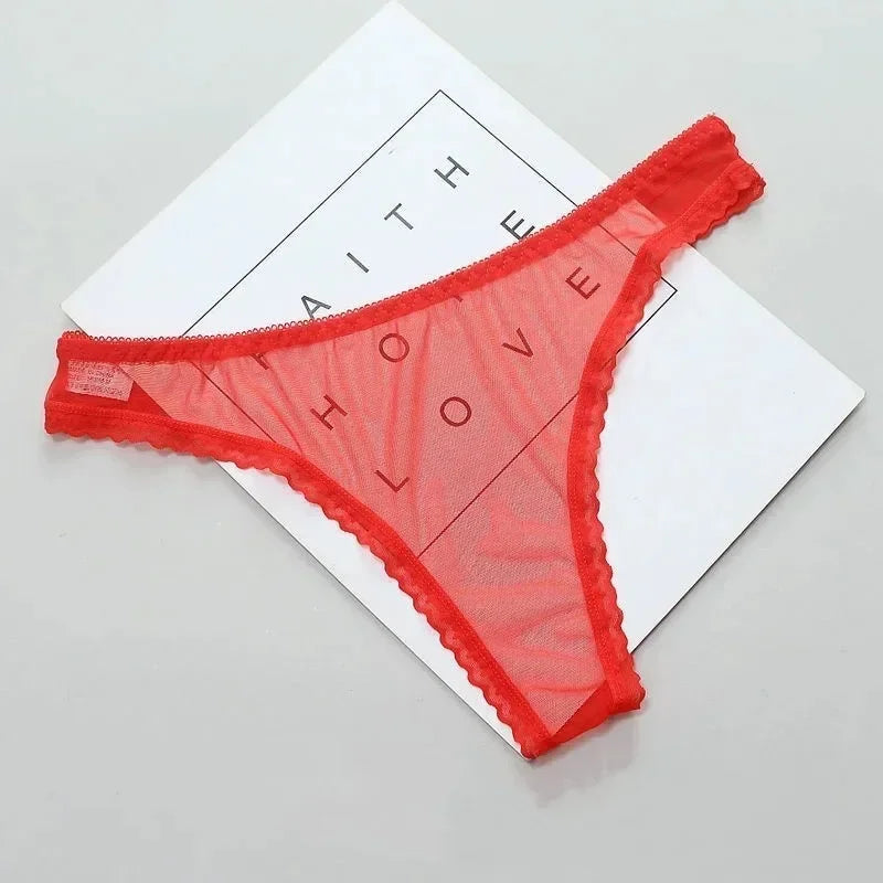 Red lace thong on a white paper with 'FAITH LOVE' text.