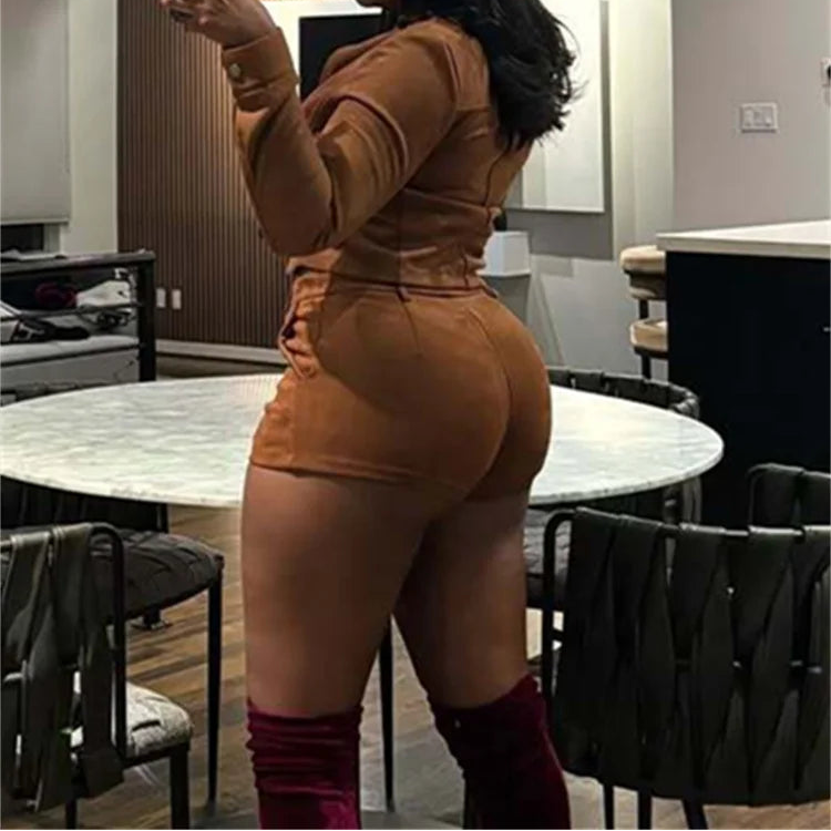 Person wearing a brown outfit taking a mirror selfie in a modern interior setting.