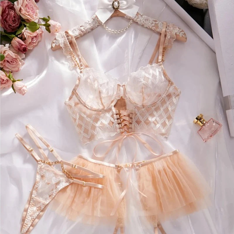 Lace lingerie set with a hanger on a white surface with flowers and a perfume bottle.