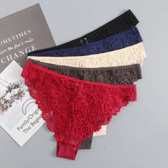 Set of lace underwear in various colors on a gray surface with a book in the background.