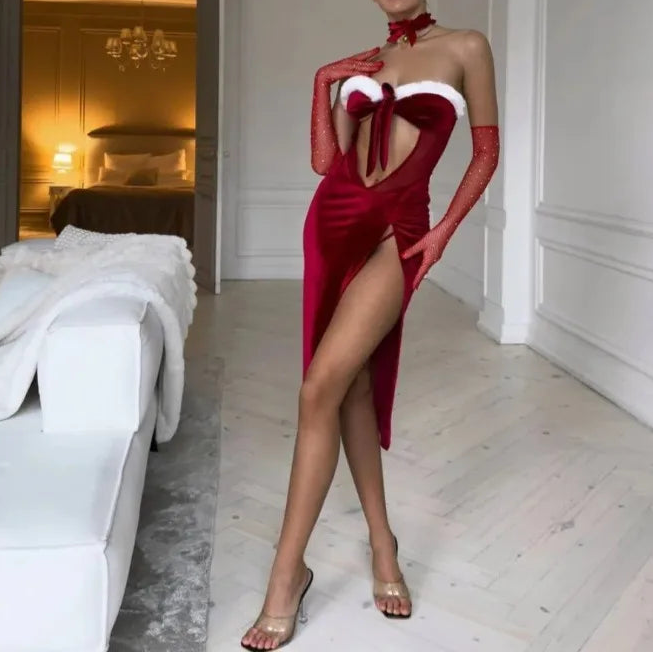 Woman in a red dress with bunny ears standing in a bedroom.