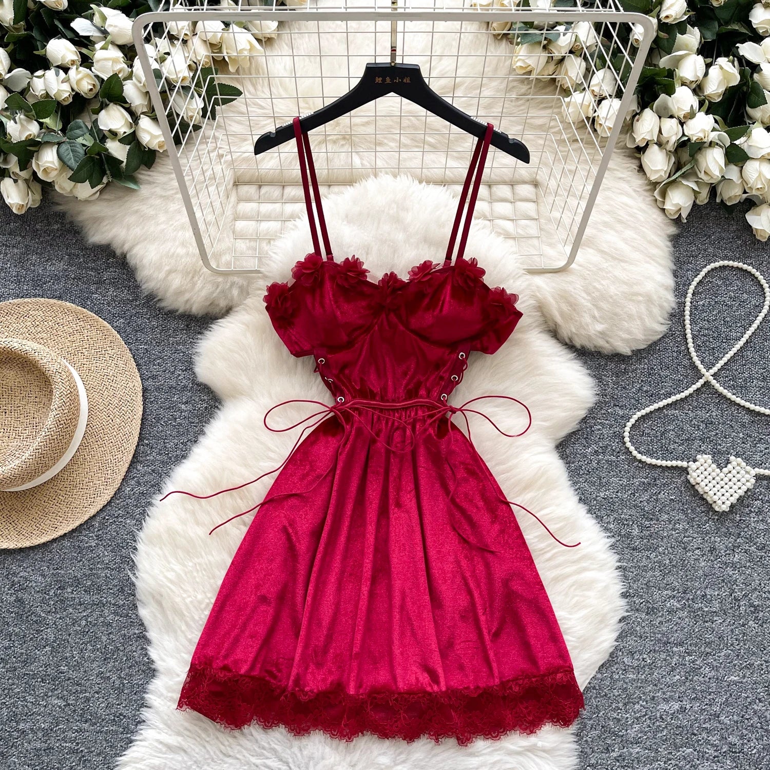 Red dress on a hanger with decorative elements on a gray surface