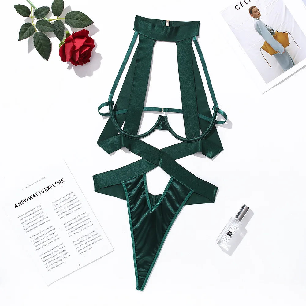 Green satin lingerie set on a white background with a flower and magazine.