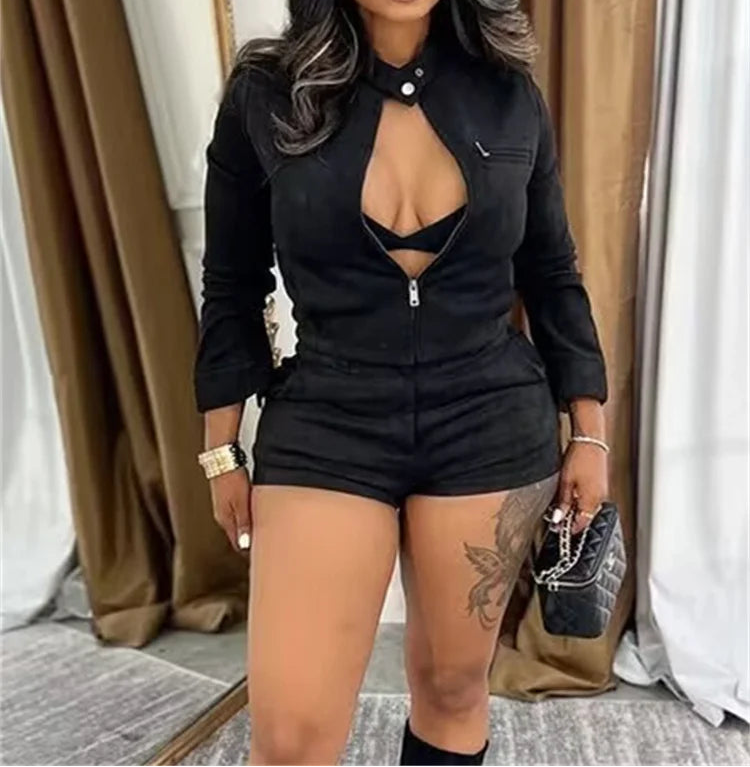 Woman in a black outfit with a cap standing indoors.