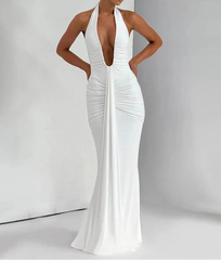 Woman wearing a white evening gown with a deep neckline on a plain background