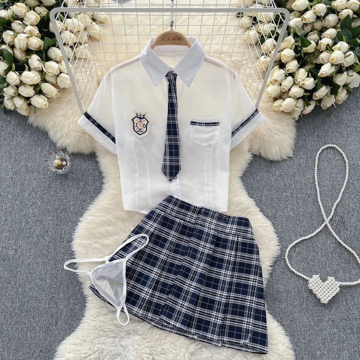 School uniform with white shirt, tie, and plaid skirt on a floral background