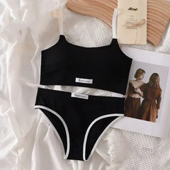 Black swimsuit with 'Fashion' label on a textured white surface