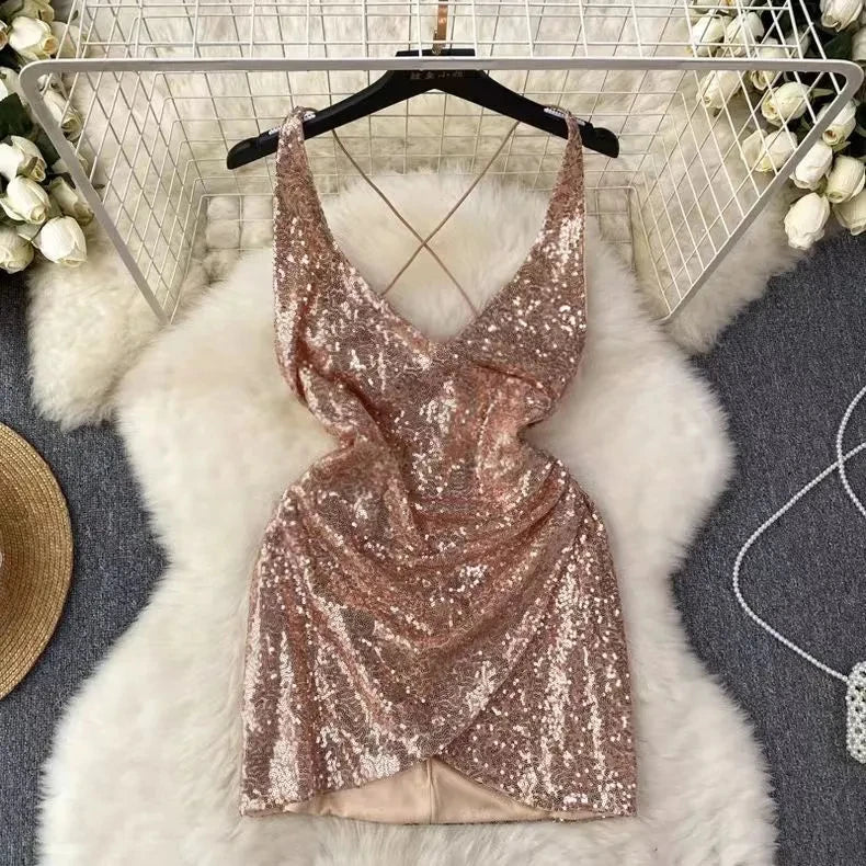 Rose gold sequin dress on a hanger with a white fur rug and decorative items in the background