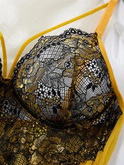 Close-up of black floral lace detailing on the yellow chemise bodice and strap.