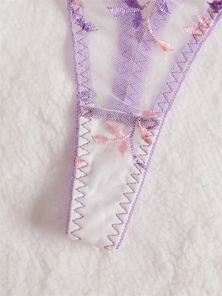 Embroidered lace trim with floral patterns on a textured white background