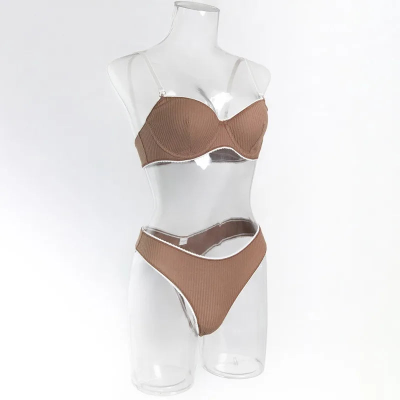 Brown ribbed bra and panties set on a clear mannequin against a white background