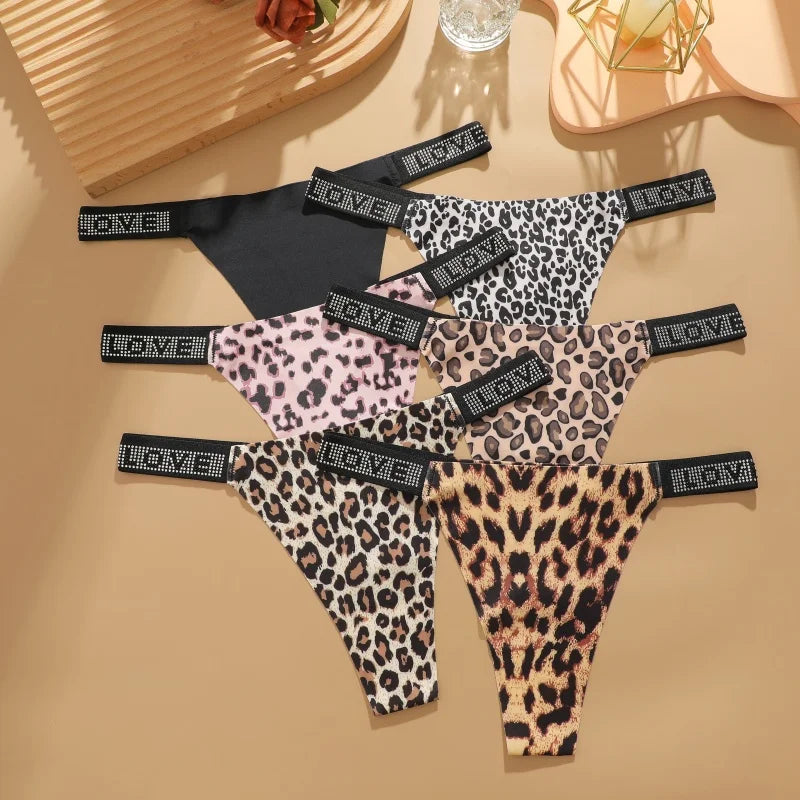 Leopard print lingerie set on a beige surface with decorative items.