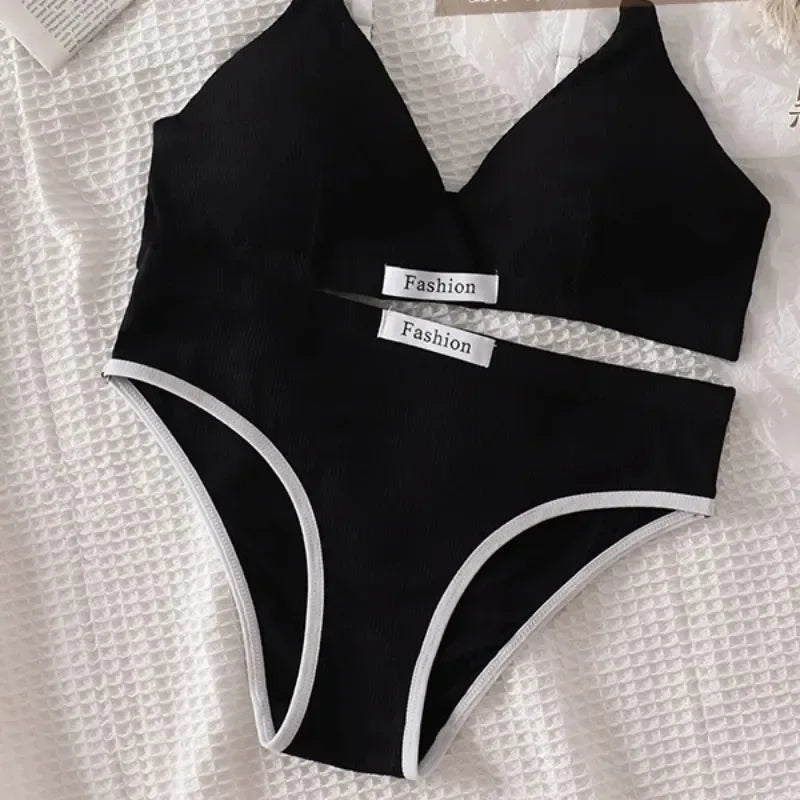 Black bikini set with 'Fashion' labels on a textured white background