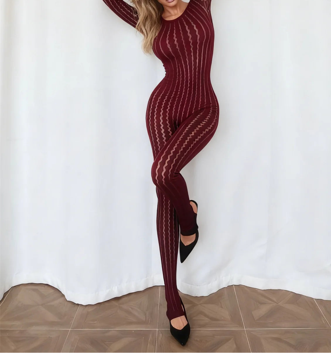 Woman wearing a maroon patterned outfit against a white background