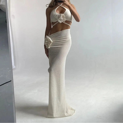 Person wearing a white crochet dress and hat taking a mirror selfie.
