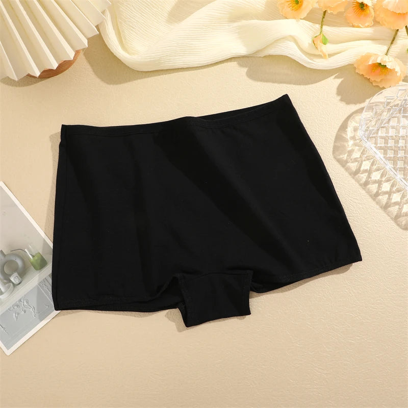Black boxer briefs on a beige surface with decorative elements