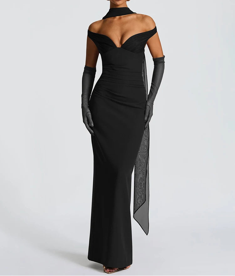Woman wearing a black evening gown with a high slit on a white background