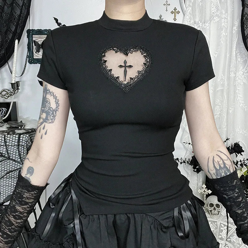 Person wearing a black t-shirt with a heart design and black gloves in a decorative room.
