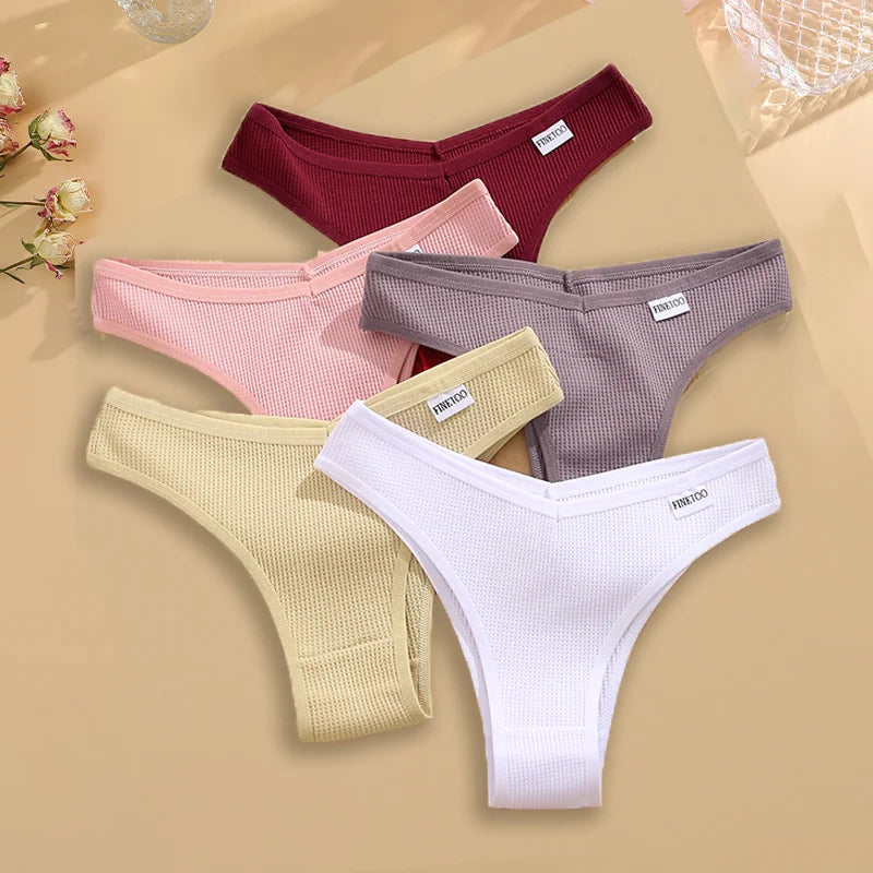 Five pairs of women's underwear in different colors on a beige background.