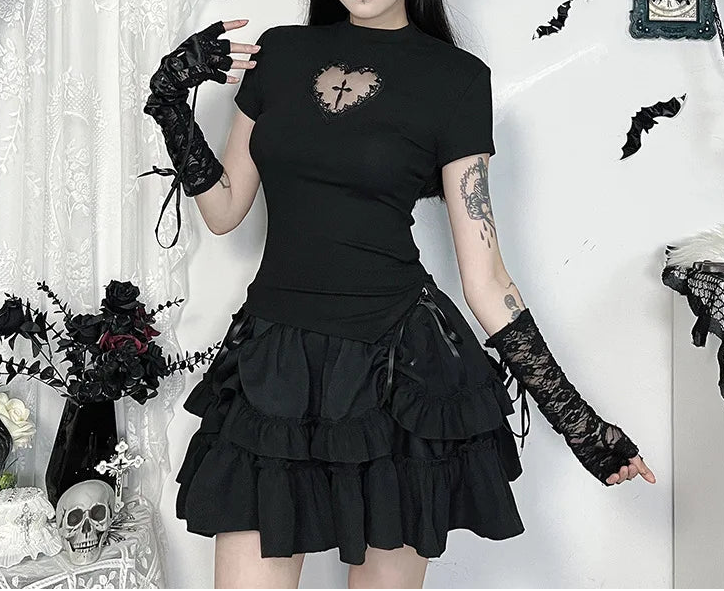 Person wearing a black outfit with lace gloves and a floral headpiece in a decorative setting.