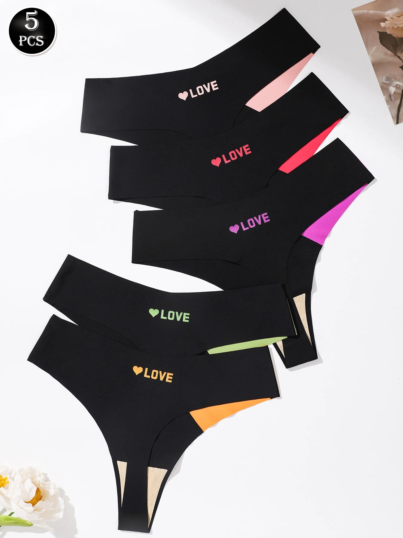 Five pairs of women's high-waisted thong underwear in black, arranged in a fan layout on a white background. Each pair features a different colored 'LOVE' text and heart graphic on the front waistband, along with a contrasting inner leg panel in matching colors.