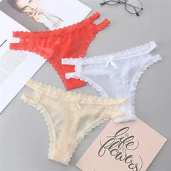 Three pairs of lace-trimmed panties in red, white, and beige on a gray surface.