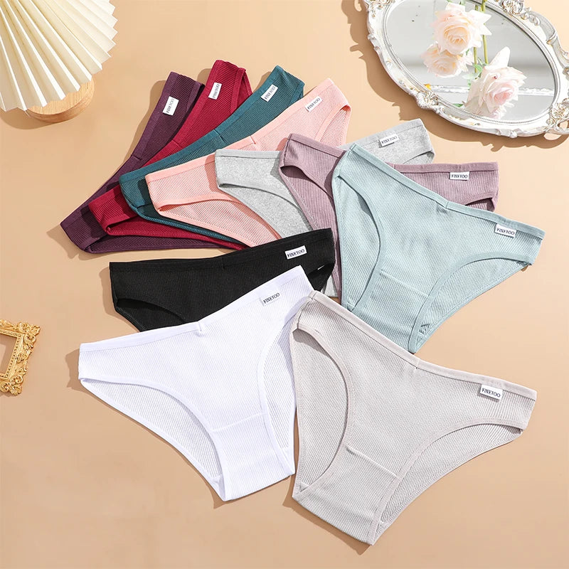 Assorted women's underwear in various colors on a beige surface.