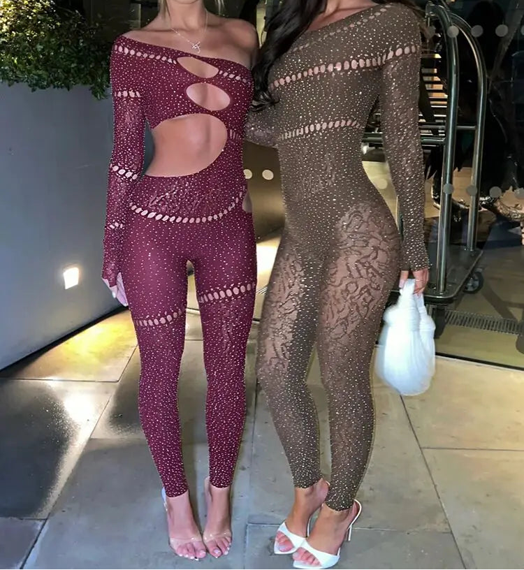 Two women wearing sheer, patterned outfits standing indoors.