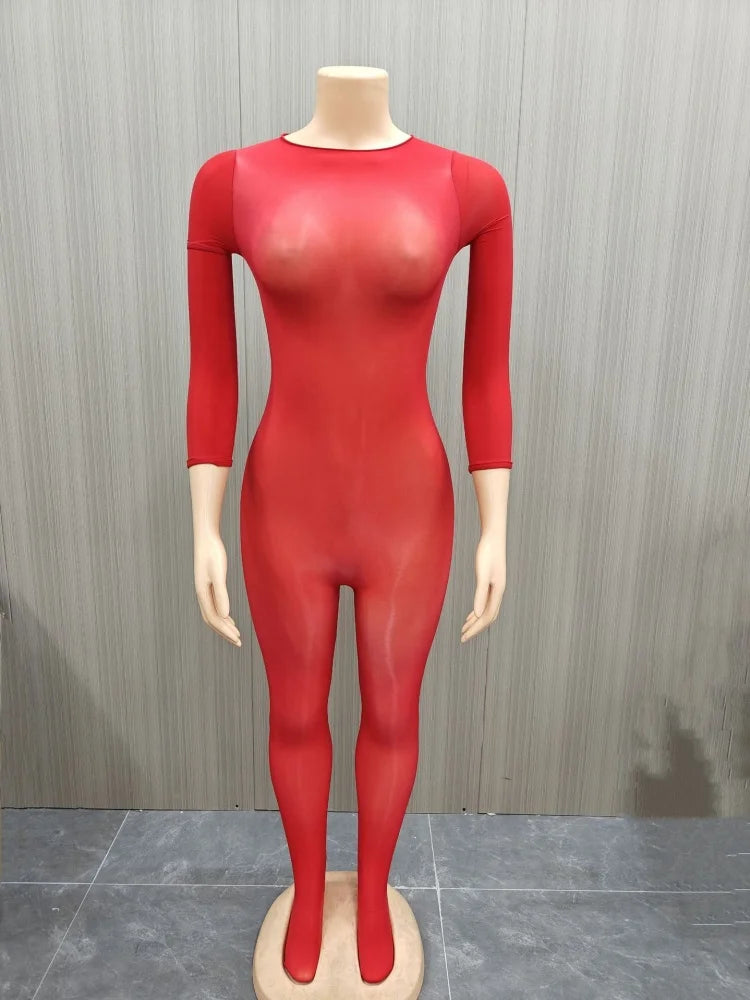 A bright red, long-sleeved bodysuit or catsuit displayed on a female mannequin against a gray wood-paneled wall.