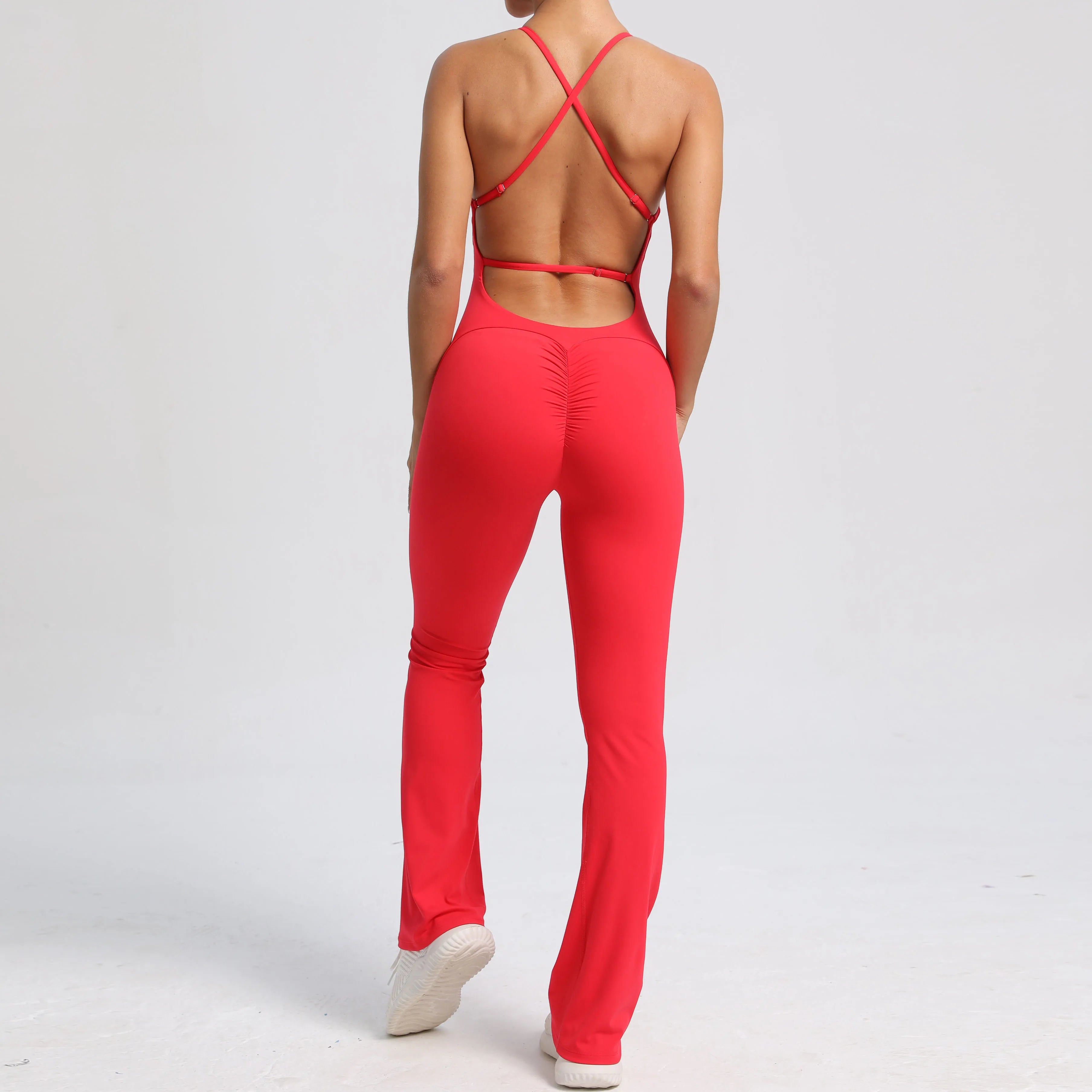 Person wearing a red jumpsuit with criss-cross back design on a white background