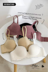 Three bras in different colors on a white surface with text and branding.