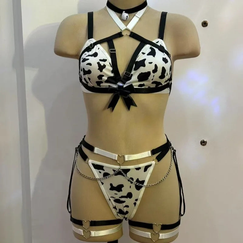 Mannequin wearing a cow print lingerie set with black straps and chains on a plain background