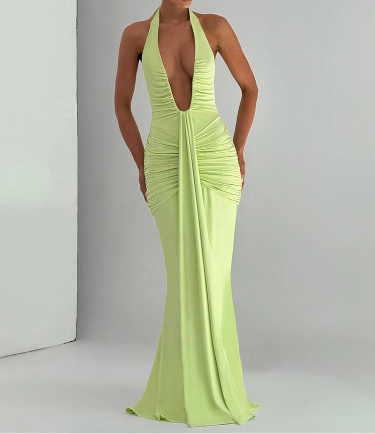Woman wearing a bright green evening gown with a plunging neckline on a plain background