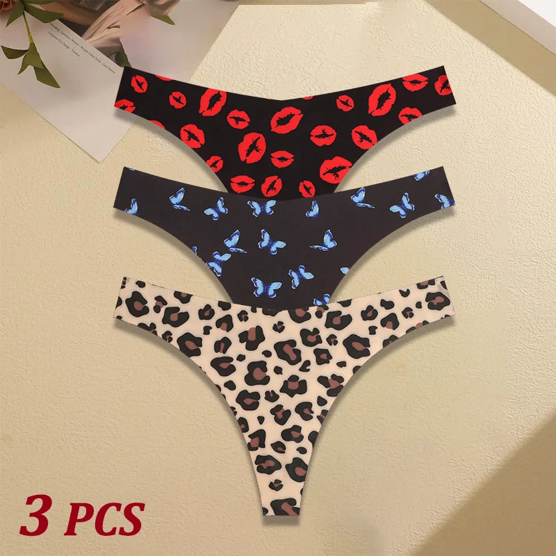 Three pairs of women's underwear with different patterns on a beige surface.
